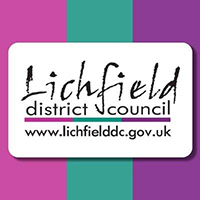 Logo for Lichfield District Council. Text in a rounded white box and backed by three wide vertical stripes in fuschia, green and purple.